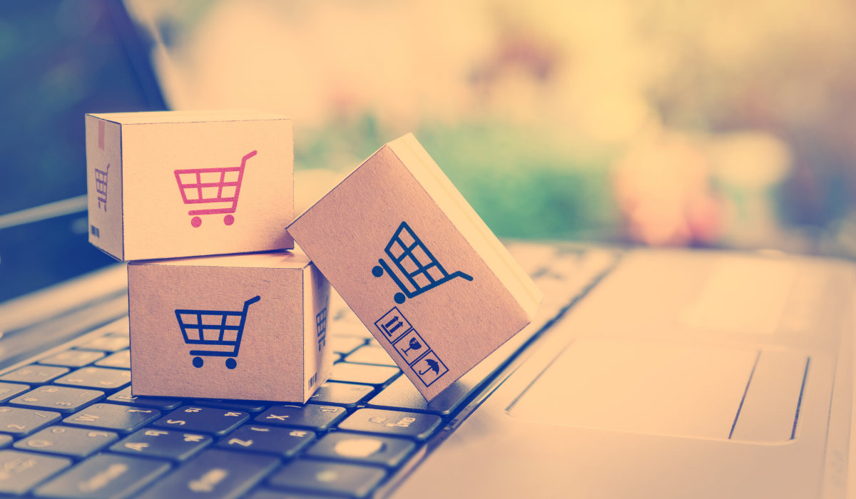 Image of little boxes with shopping carts printed on them on laptop keypad. For blog article What are the Shopify Plus requirements?