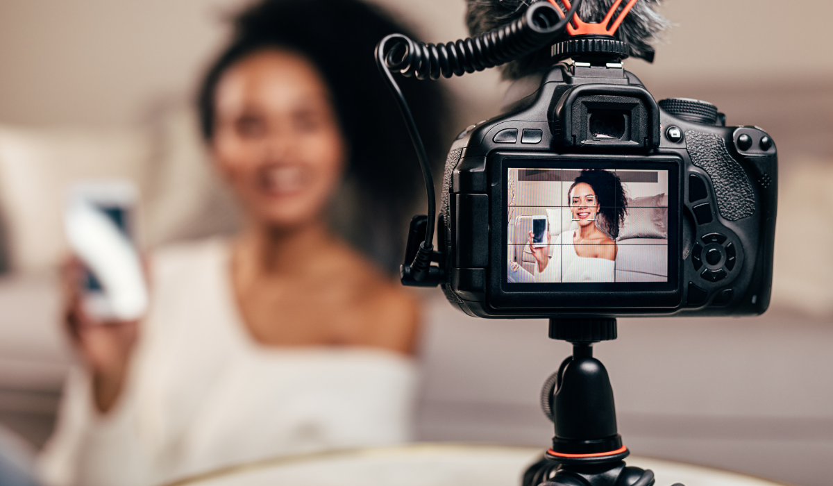 Camera on tripod filming woman holding mobile phone