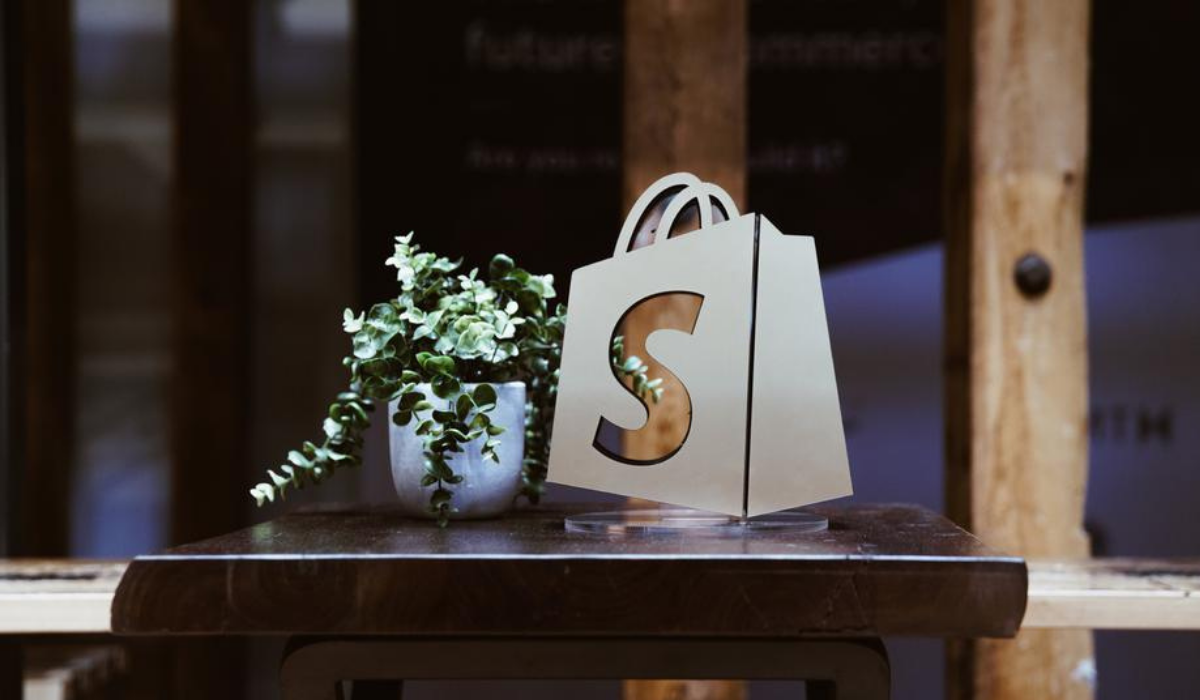Shopify bag logo on a table with a plant