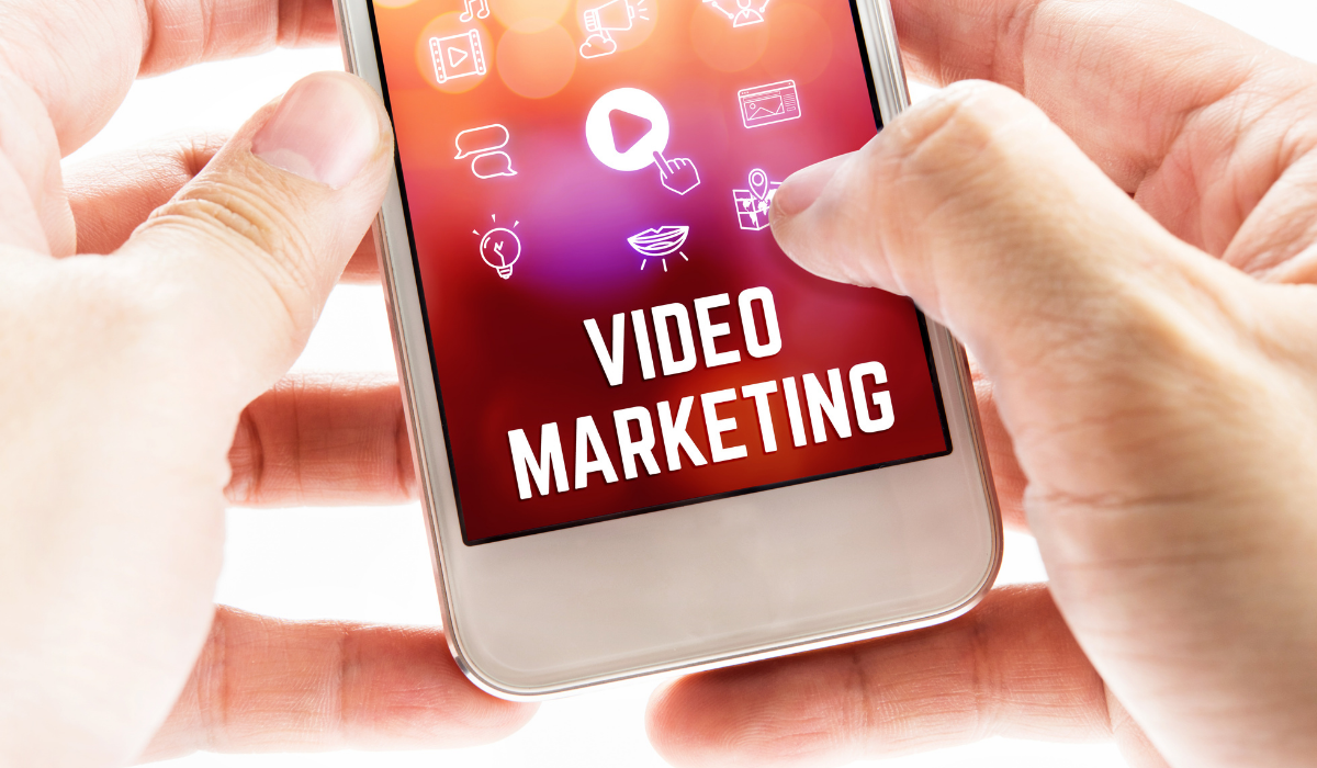 Why and How to Use Video Marketing for Ecommerce Store. Close up of hands holding mobile phone with works video marketing on screen