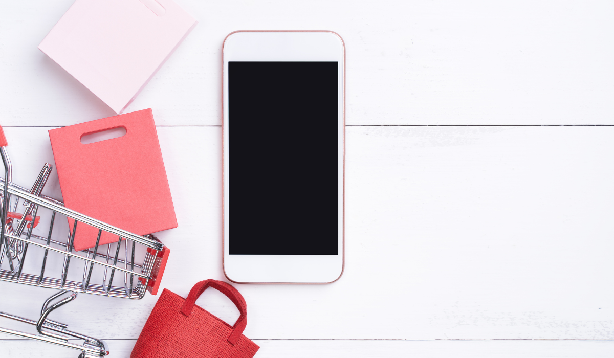 Banner image shopping cart and mobile phone. For blog article 6 Shopify Marketing Tactics: Drive Sales From Mobile Customers